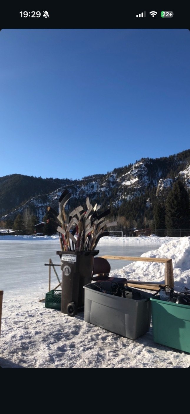 Hockey sticks by a frozen pond in the mountains